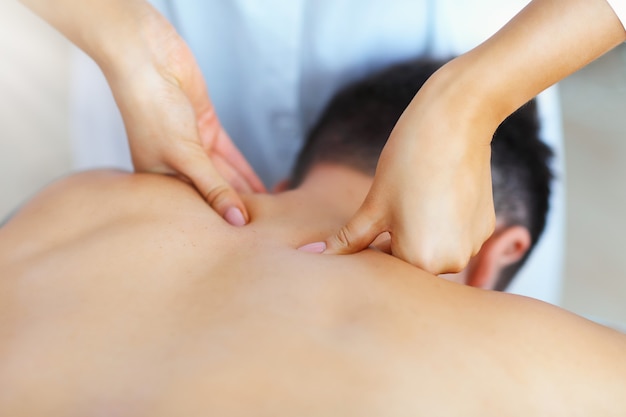 handsome man having massage in spa salon