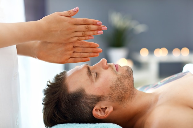 handsome man having massage in spa salon