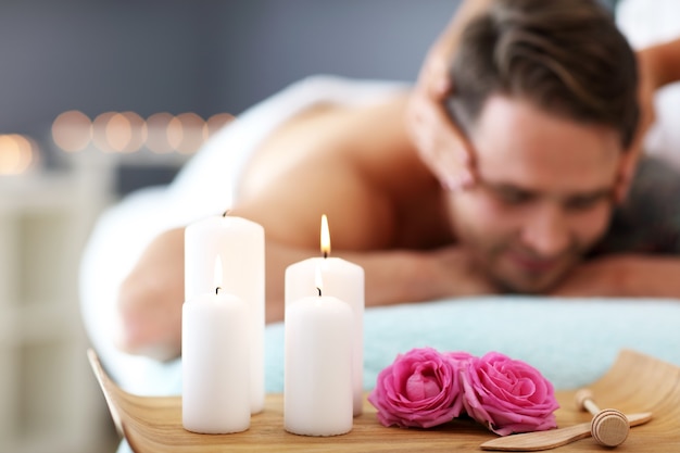 handsome man having massage in spa salon