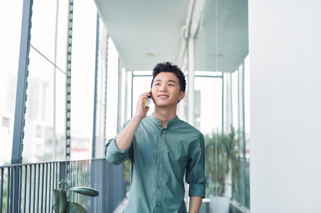 Handsome man having serious conversation on cell phone outside on balcony