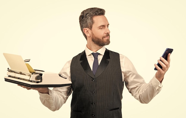 Handsome man hold retro typewriter and modern smartphone technology