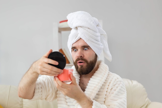 Handsome man holding cosmetic pink scrub for skin spa body and skin care for man concept