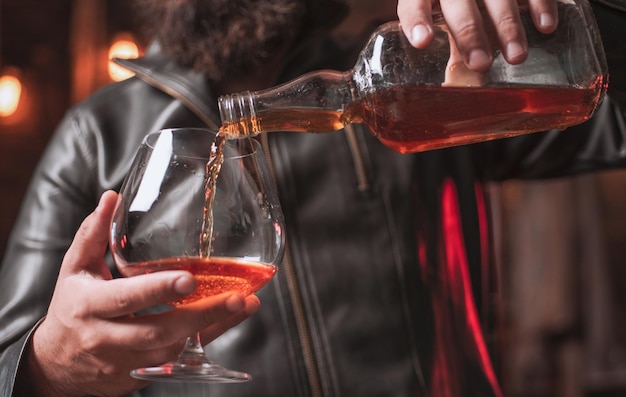 Handsome man holding a glass of whisky sipping whiskey degustation tasting man holding a glass of wh