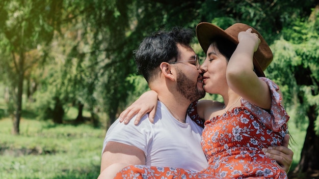 Handsome man holding his girlfriend in his hands in a park.