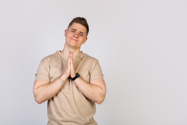 Handsome man holding his palms pressed together