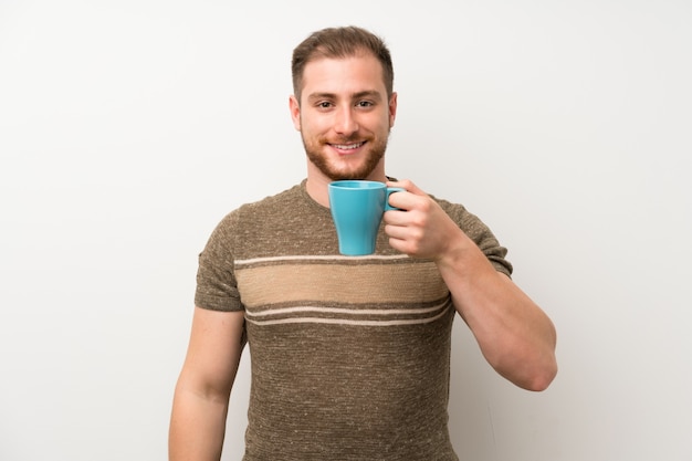 Uomo bello che tiene tazza di caffè calda