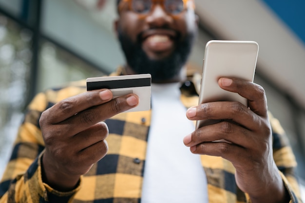 Handsome man holding mobile and shopping online