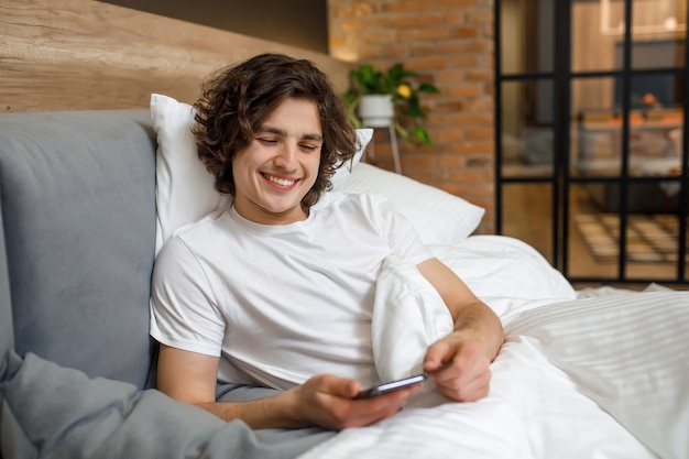 Handsome man holding phone while getting up.