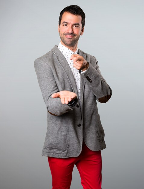 Handsome man holding something on grey background