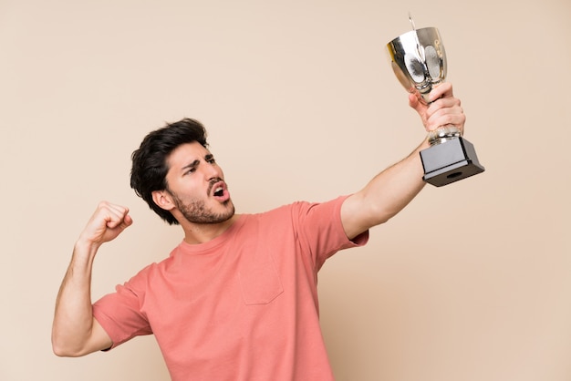 Photo handsome man holding a trophy