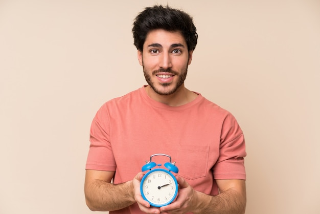 Handsome man holding vintage alarm clock