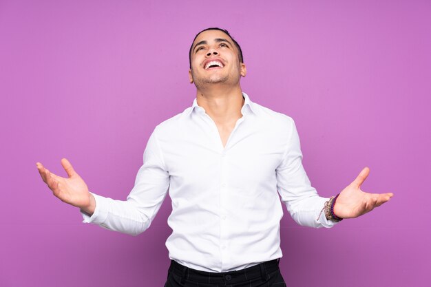 Handsome man isolated on blue wall smiling a lot