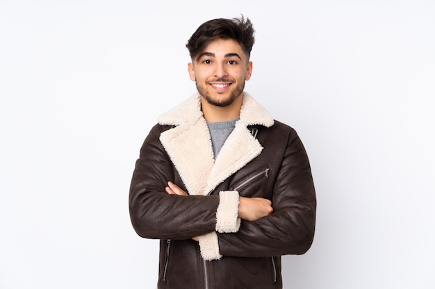 Handsome man over isolated wall keeping the arms crossed in frontal position