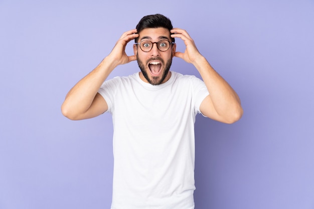 Handsome man over isolated wall with surprise expression