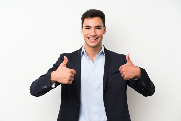 Handsome man over isolated white wall giving a thumbs up gesture