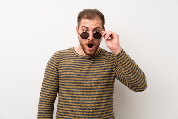 Handsome man isolated white wall with glasses