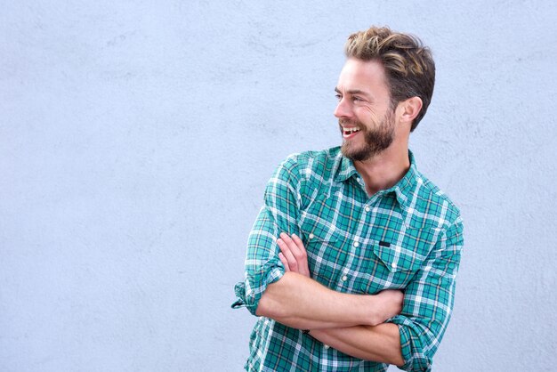 Handsome man laughing with arms crossed