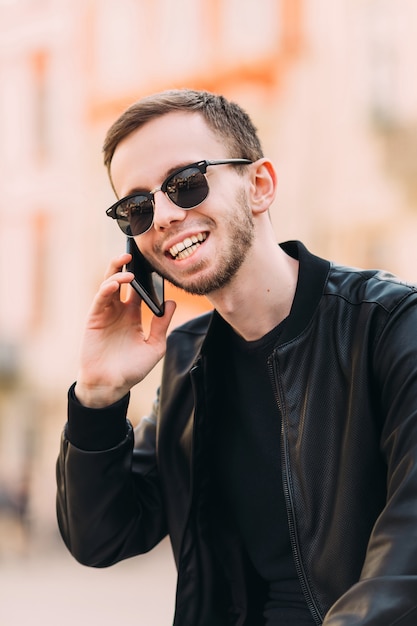 Handsome man in a leather jacket with sunglasses