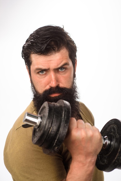 Un bell'uomo che solleva un manubrio in palestra, uno stile di vita sportivo sano, il concetto di fitness si adatta al giovane in