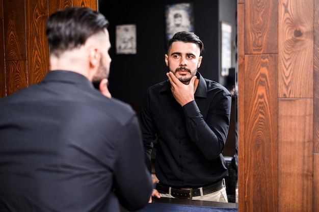 Photo handsome man looking in a mirror