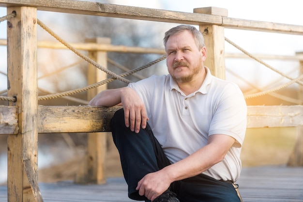 Handsome man looks thoughtfully into the distance in the summer outdoors