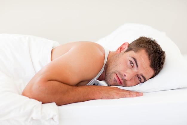 Handsome man lying in bed