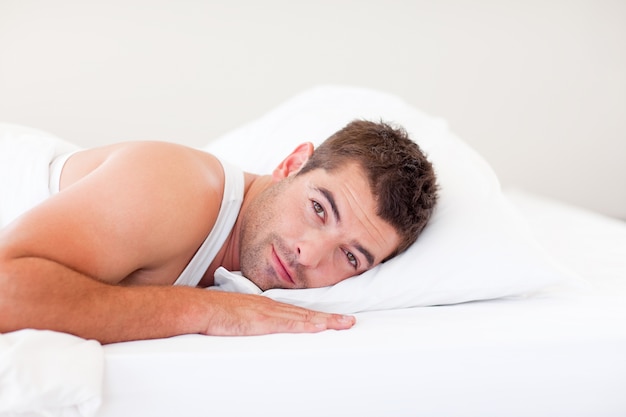 Handsome man lying in bed