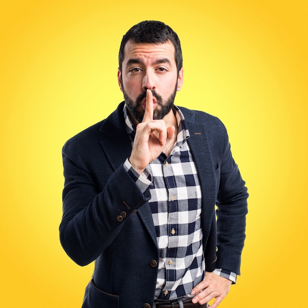 Handsome man making silence gesture on colorful background