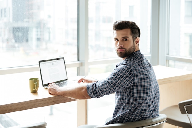 Handsome man in office coworking while using laptop computer