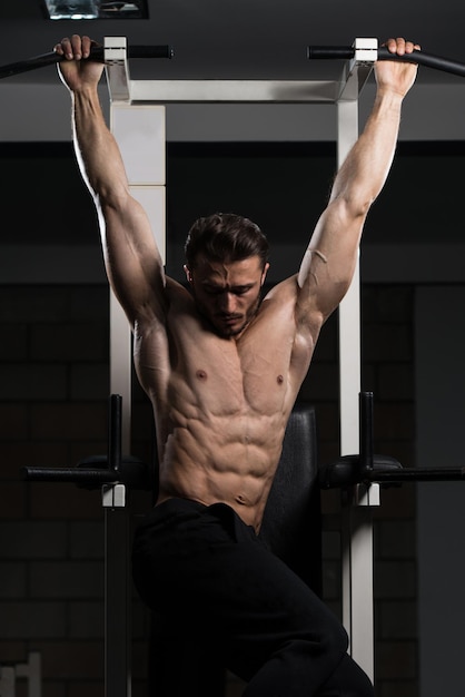 Handsome Man Performing Hanging Leg Raises Exercise  One Of The Most Effective Ab Exercises