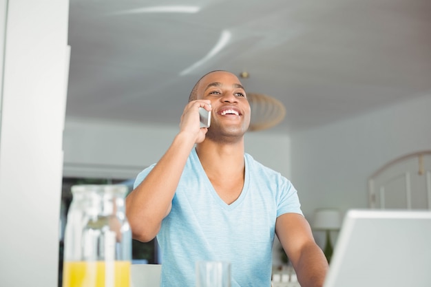 Handsome man on a phone call in the kitchen