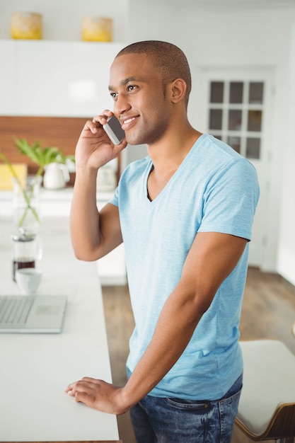 Handsome man on a phone call in the kitchen