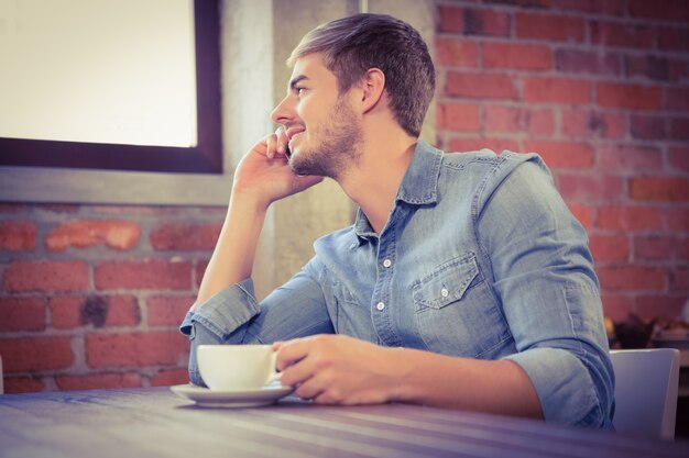 Handsome man phoning and looking out of window