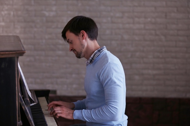 Photo handsome man plays piano in the class