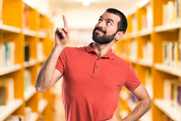 Handsome man pointing up on unfocused background