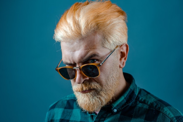 Handsome man. Portrait of stylish handsome young man with sunglasses. Handsome male model - beard mustache and blonde hairdo with casual shirt.