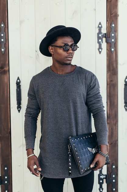 handsome man posing in front of a wooden door