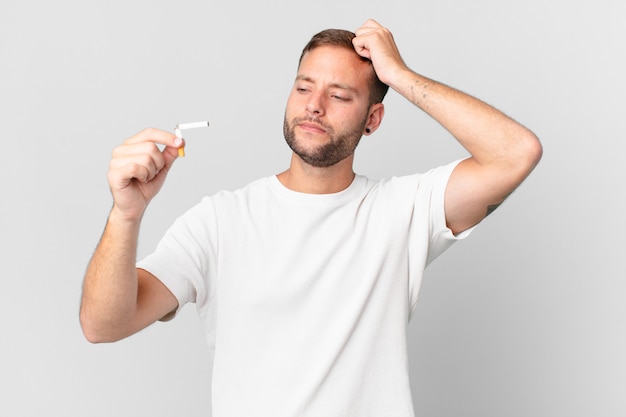 Handsome man quitting smoking with a broken cigar