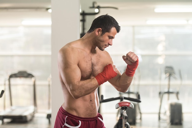 Красивый мужчина в красных боксерских перчатках Бокс в тренажерном зале Концепция здорового образа жизни Идея фильма о боксе