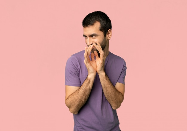 Handsome man scheming something on isolated pink background