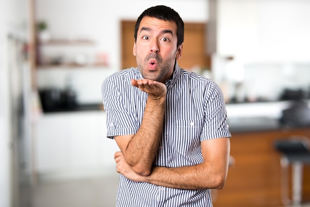 Handsome man sending a kiss inside house