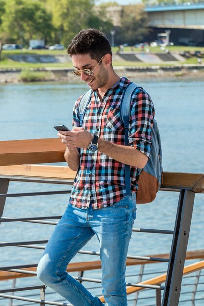 Handsome man sending text message.