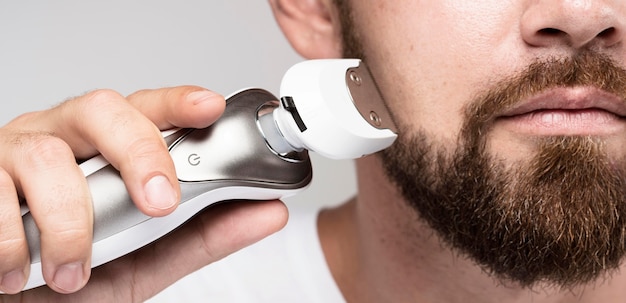 Photo handsome man shaving close-up