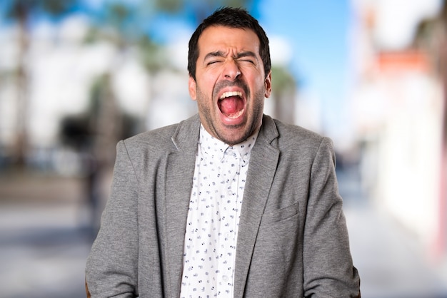 Handsome man shouting on unfocused background