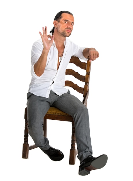 Handsome man sitting on a chair and showing ok sign