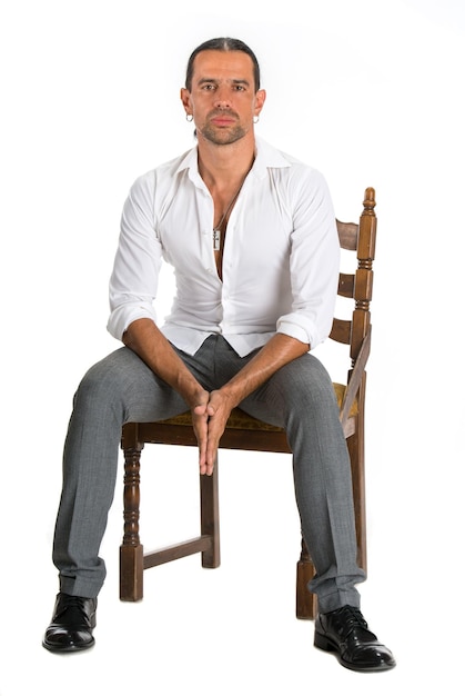 Uomo bello che si siede su una sedia