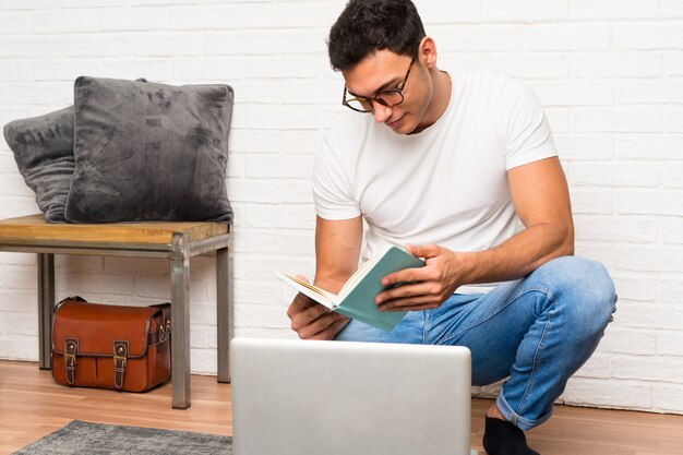 Handsome man sitting on the floor with his laptop