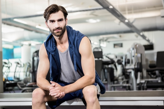 Handsome man sitting in the gym looking at the camera