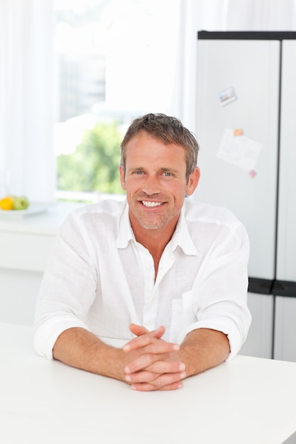 Handsome man sitting in his kitchen