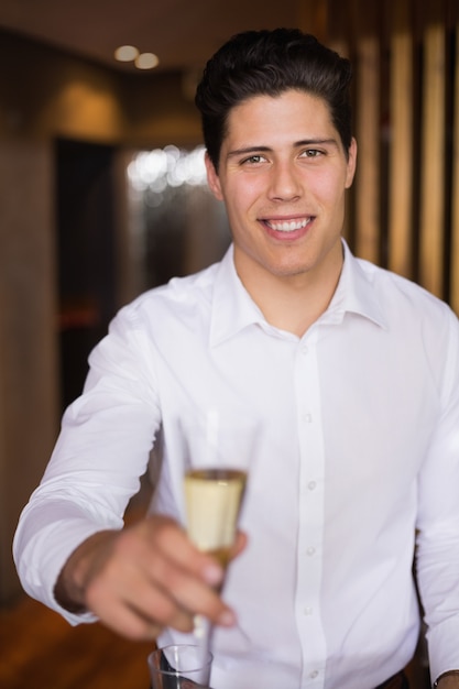 Handsome man smiling at camera holding champagne